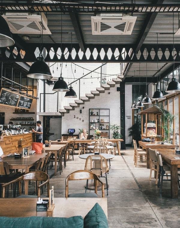 Interior de um café com mesas de madeira